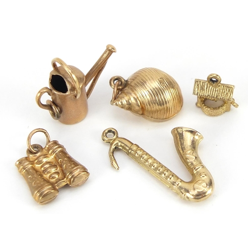 1701 - Five 9ct gold charms including saxophone, binoculars and watering can, the largest 2.5cm high, total... 