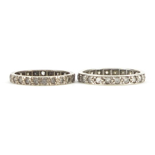 1952 - Two unmarked white metal clear stone eternity rings, sizes N and P, 3.9g