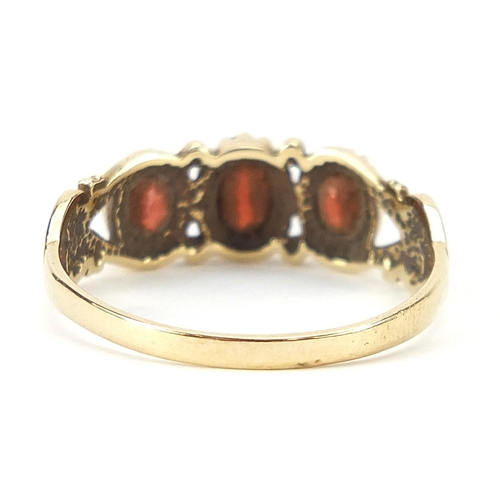 1778 - 9ct gold garnet three stone ring with ornate shoulders, size S, 2.2g