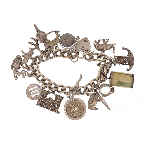 1935 - Silver charm bracelet with a selection of mostly silver charms including emergency one pound note, o... 