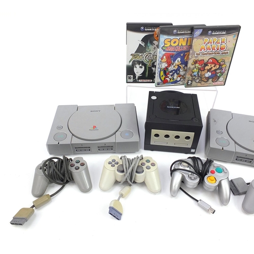 1523 - Two PlayStation 1 consoles with controllers and a Nintendo Game Cube console with controllers and ga... 