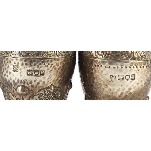 2262 - Pair of Arts & Crafts silver casters with engraved, planished and embossed decoration, indistinct ma... 