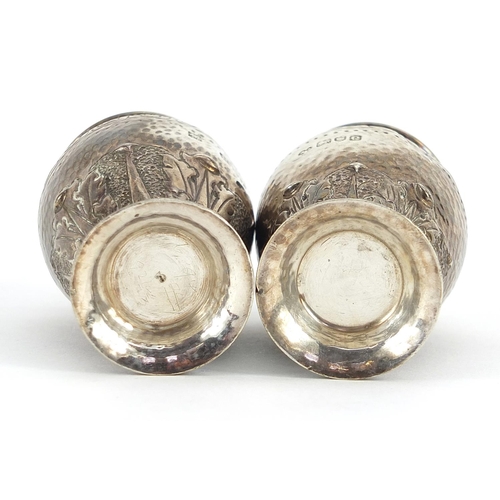 2262 - Pair of Arts & Crafts silver casters with engraved, planished and embossed decoration, indistinct ma... 