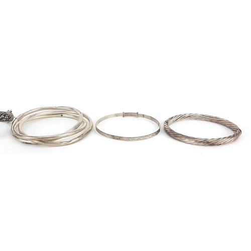 2175 - Seven silver bangles including Thai niello work, 89.8g