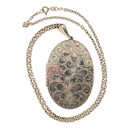 2001 - Large oval silver locket with engraved decoration on a silver necklace, 7cm high and 54cm in length,... 