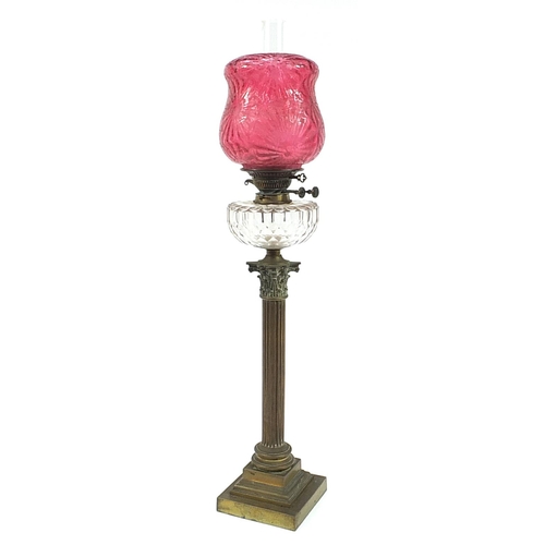 48 - Victorian brass Corinthian column oil lamp with cranberry glass shade and clear glass reservoir, 82c... 