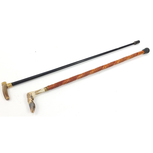 1131 - Two walking sticks with horn and deer foot handles, the largest 93cm in length