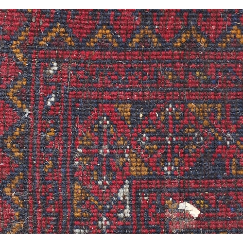 872 - Red ground rug having an all over geometric design, 135cm x 80cm