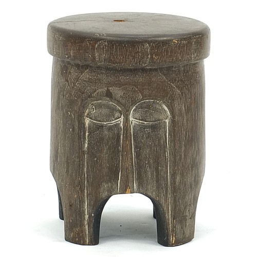 903 - African carved wood face mask stool, made in Ghana label to the underside, 63cm high x 27cm in diame... 