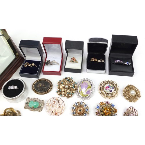 1360A - Costume jewellery and a glass display case, including rings, brooches and necklaces, the cabinet 33c... 