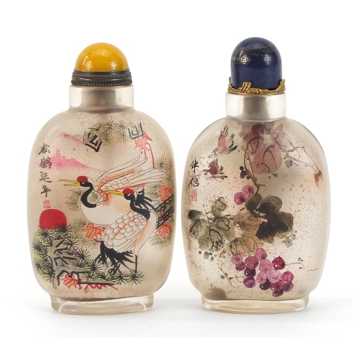 966 - Two Chinese glass snuff bottles with stoppers, internally painted with flowers and storks, each 9.5c... 