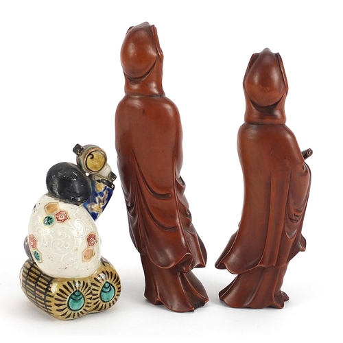 721 - Pair of Chinese carved wood figures of Guanyin and a Japanese porcelain figure of a man holding a sa... 