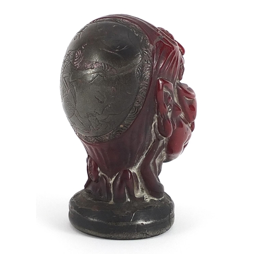 757 - Cherry amber coloured face design seal formed of nude figures with applied white metal mounts, four ... 