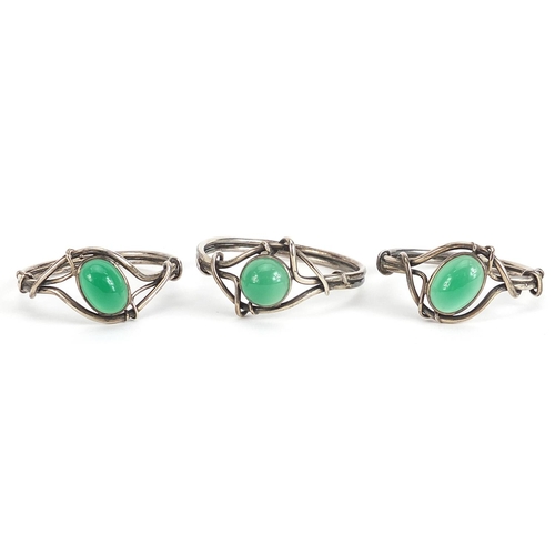 752 - Set of three white metal napkin rings set with green cabochon stones housed in a silk lined fitted b... 