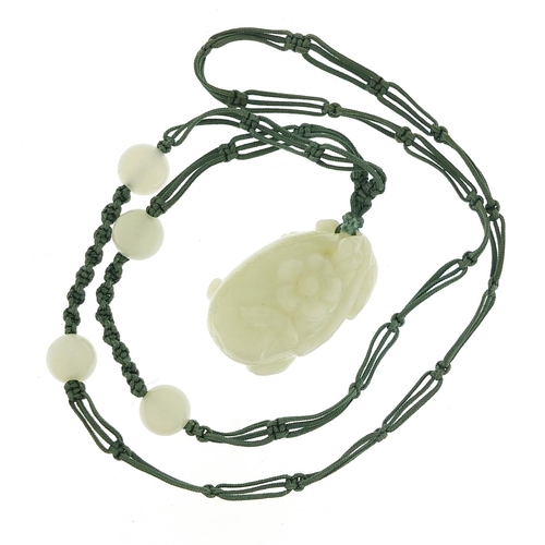 673 - Chinese pale green jade fruit pendant carved with a flower on cord necklace with jade beads, the pen... 