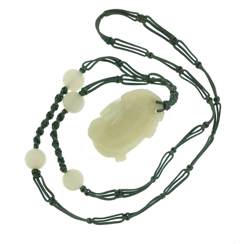 673 - Chinese pale green jade fruit pendant carved with a flower on cord necklace with jade beads, the pen... 