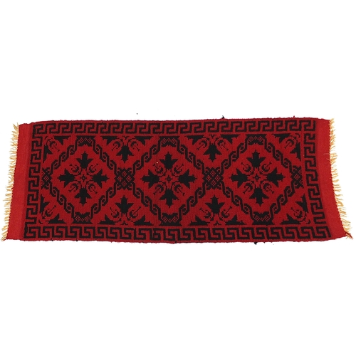 860 - Rectangular red ground carpet runner having an abstract floral design and Greek key border, 165cm x ... 