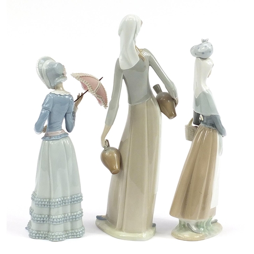 560 - Three large Lladro figurines including a lady wearing a bonnet holding a parasol, the largest 40cm h... 