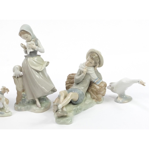 556 - Six Lladro figures and animals including a boy with bird and girl with doves, the largest 28.5cm hig... 