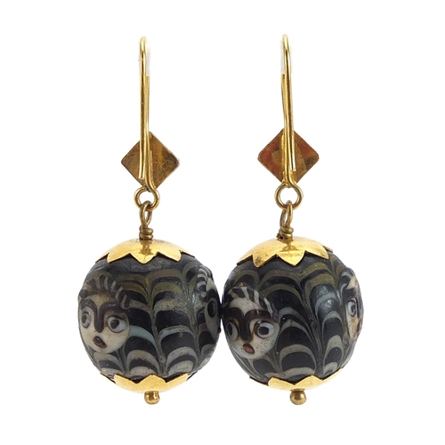 2057 - Pair of Islamic unmarked gold mounted glass earrings, hand painted with face masks, 4cm high, 12.8g