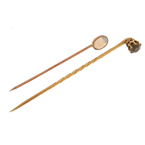 1975 - Two gold stickpins comprising one 9ct gold set with a cabochon opal and one unmarked gold set with a... 