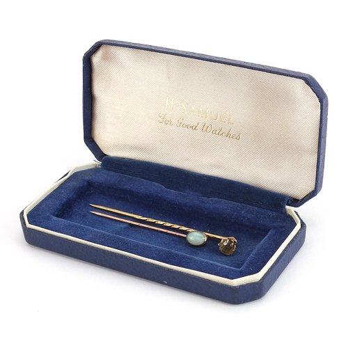 1975 - Two gold stickpins comprising one 9ct gold set with a cabochon opal and one unmarked gold set with a... 