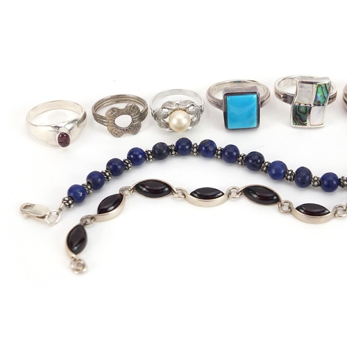 2084 - Nine silver and white metal rings and two bracelets, some set with semi precious stones, total weigh... 