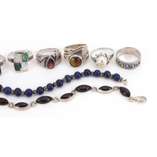 2084 - Nine silver and white metal rings and two bracelets, some set with semi precious stones, total weigh... 