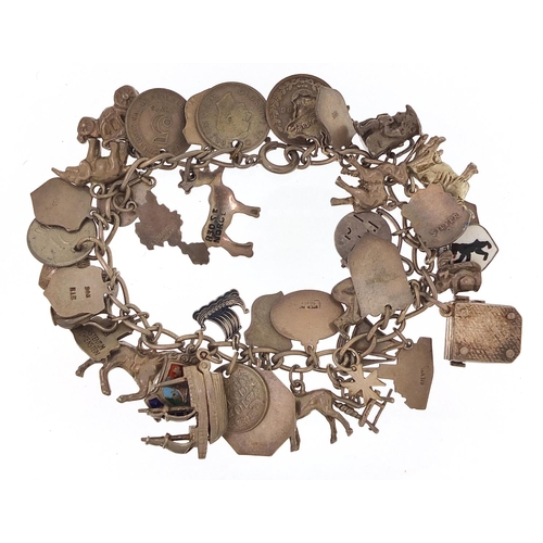 1780 - Silver charm bracelet with a large selection of mostly silver charms, 84.4g