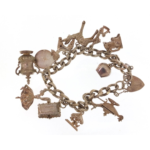 1794 - Silver charm bracelet with a selection of mostly silver charms, 61.0g