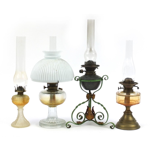 933 - Four antique and later oil lamps, three with glass reservoirs including one with a painted wrought m... 
