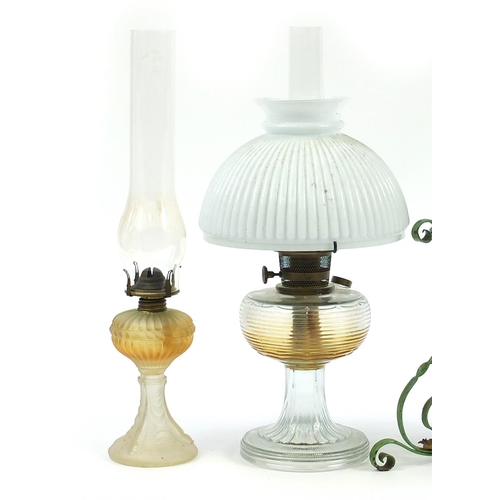 933 - Four antique and later oil lamps, three with glass reservoirs including one with a painted wrought m... 