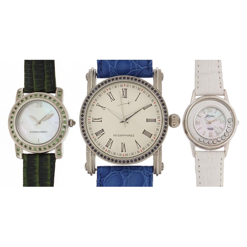 2165 - Three silver wristwatches set with blue sapphires, topaz and aquamarine, with certificates