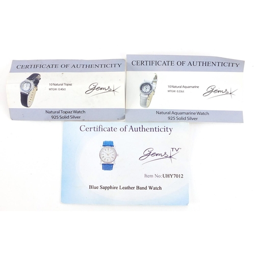 2165 - Three silver wristwatches set with blue sapphires, topaz and aquamarine, with certificates