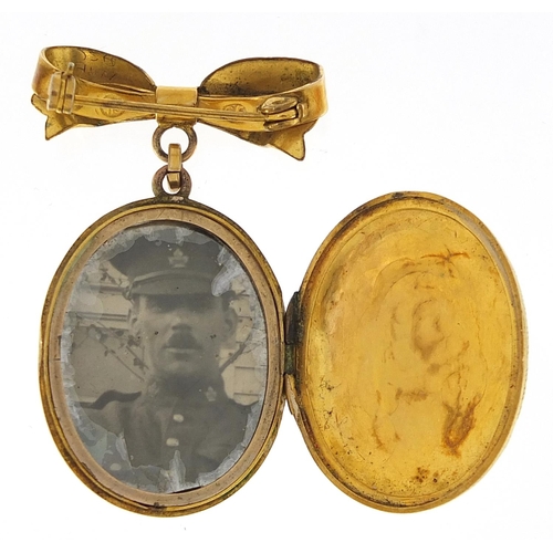 1819 - Victorian gilt metal locket engraved with flowers and foliage on a yellow metal bow brooch fitting, ... 