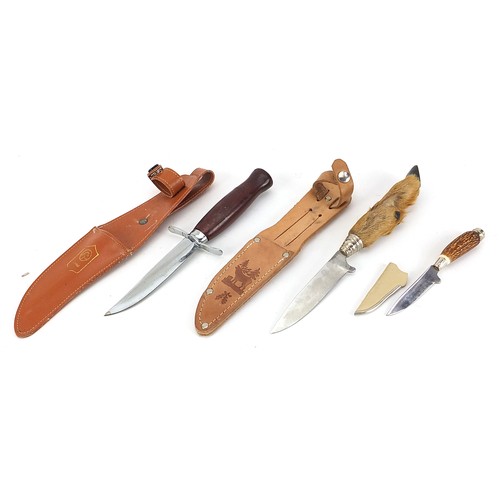 2373 - Three hunting knives with leather sheaths including one with deer foot handle, the largest 23cm in l... 