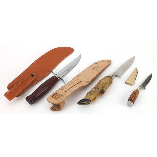 2373 - Three hunting knives with leather sheaths including one with deer foot handle, the largest 23cm in l... 