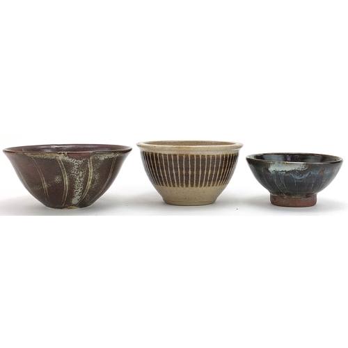 Three studio pottery bowls including examples by Tim Andrews and Kenneth Quick, each with impressed marks around the footrim, the largest 12.5cm in diameter