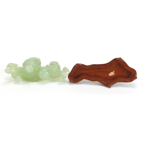 990 - Chinese green jadeite carving of two qilins raised on carved hardwood stand, 18cm in length