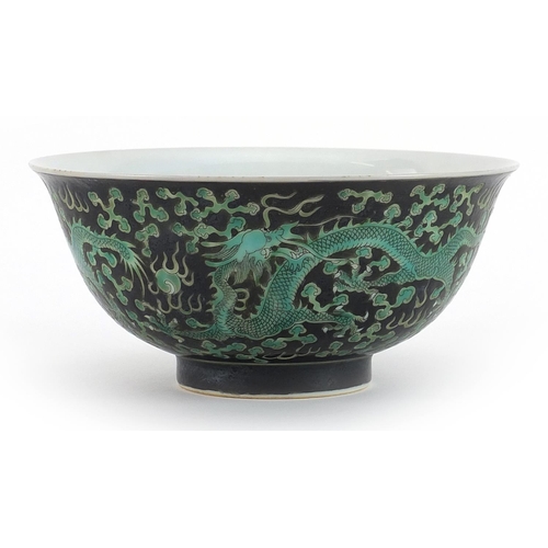 494 - Chinese porcelain black ground bowl hand painted with dragons chasing pearl amongst clouds, 16cm in ... 