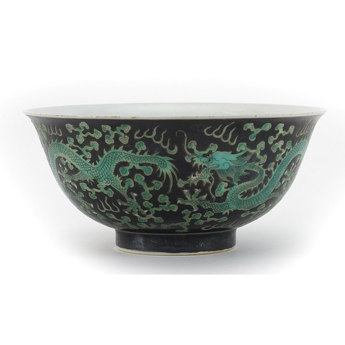 494 - Chinese porcelain black ground bowl hand painted with dragons chasing pearl amongst clouds, 16cm in ... 