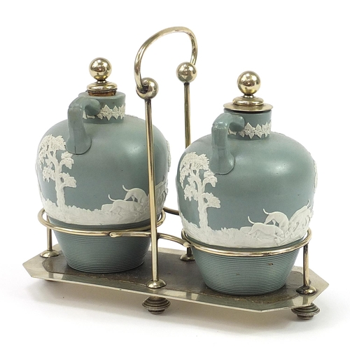 217 - 19th century brandy and whiskey salt glazed flagons housed in a silver plated tantalus, the bottles ... 