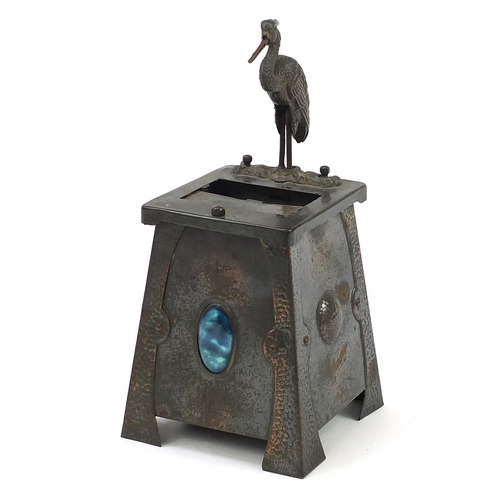 464 - Arts & Crafts hammered copper cigarette dispenser surmounted with a heron, inset with a Ruskin type ... 