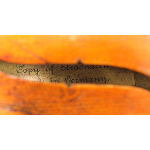 411A - German violin with two piece back, bow and case, the violin bearing a Stradivarius paper label, the ... 