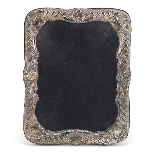 2257 - Ray Hall, rectangular silver easel photo frame embossed with shells, indistinct hallmarks, 16.5cm x ... 