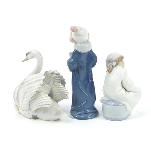 562 - Two Lladro porcelain figures and a swan, the largest 25cm high