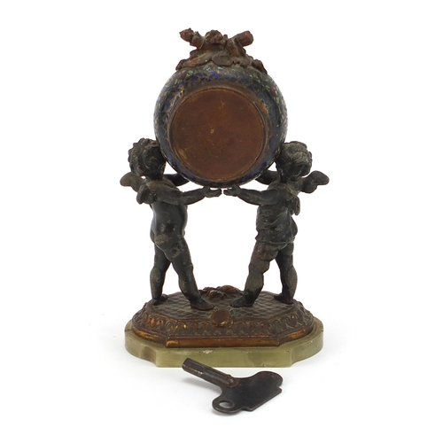 410 - Champleve enamel and patinated spelter mantle clock with two Putti, the circular enamelled dial pain... 