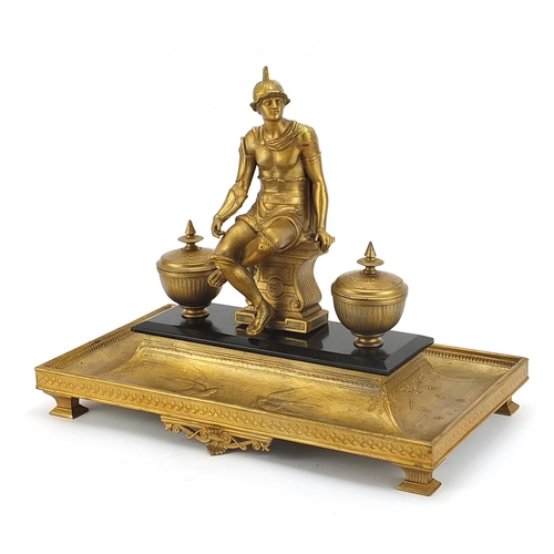 511 - Gilt metal desk stand with two inkwells surmounted with a gladiator, 40cm wide