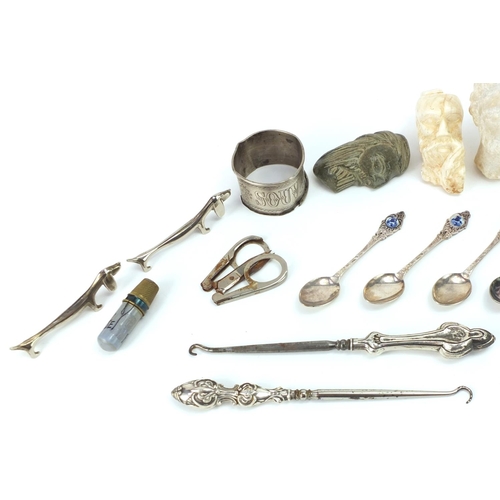 656 - Objects including antique carved stone heads, Dachshund design silver plated knife rests, silver han... 