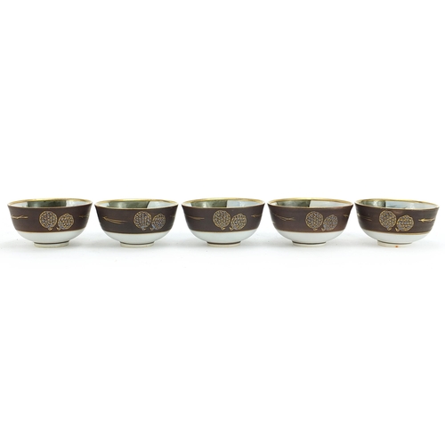 1117 - Five Japanese porcelain tea bowls hand painted with landscape scenes housed in a fitted case, each 5... 